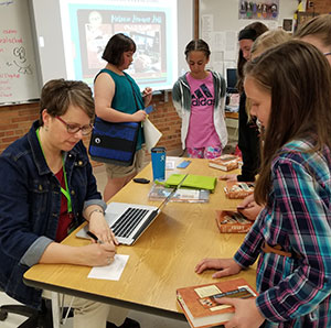 Melanie Heuiser Hill signing books